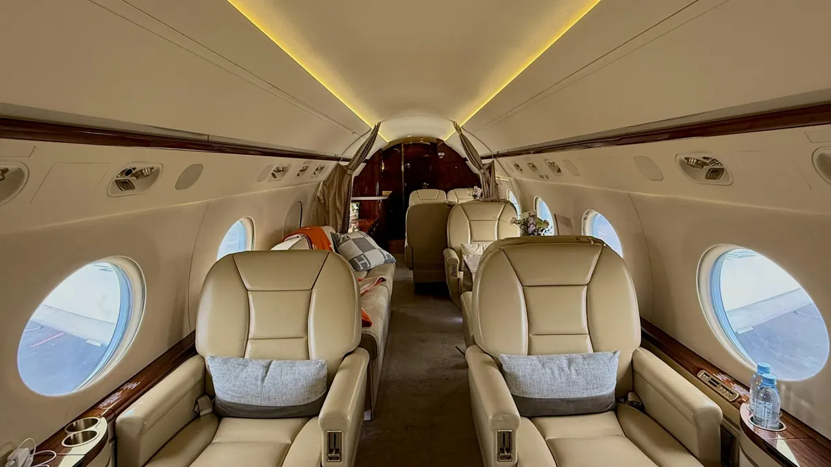 Leather club seats in a private jet cabin lit by the windows