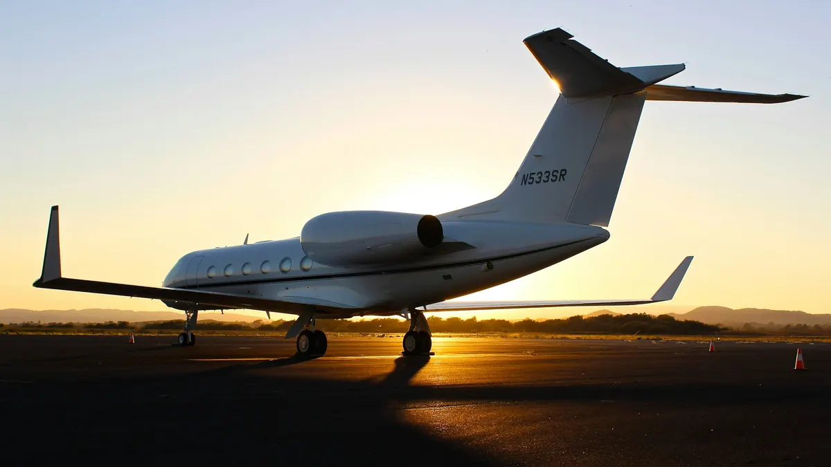 A Gulfstream jet silhouetted on the ramp at sunset