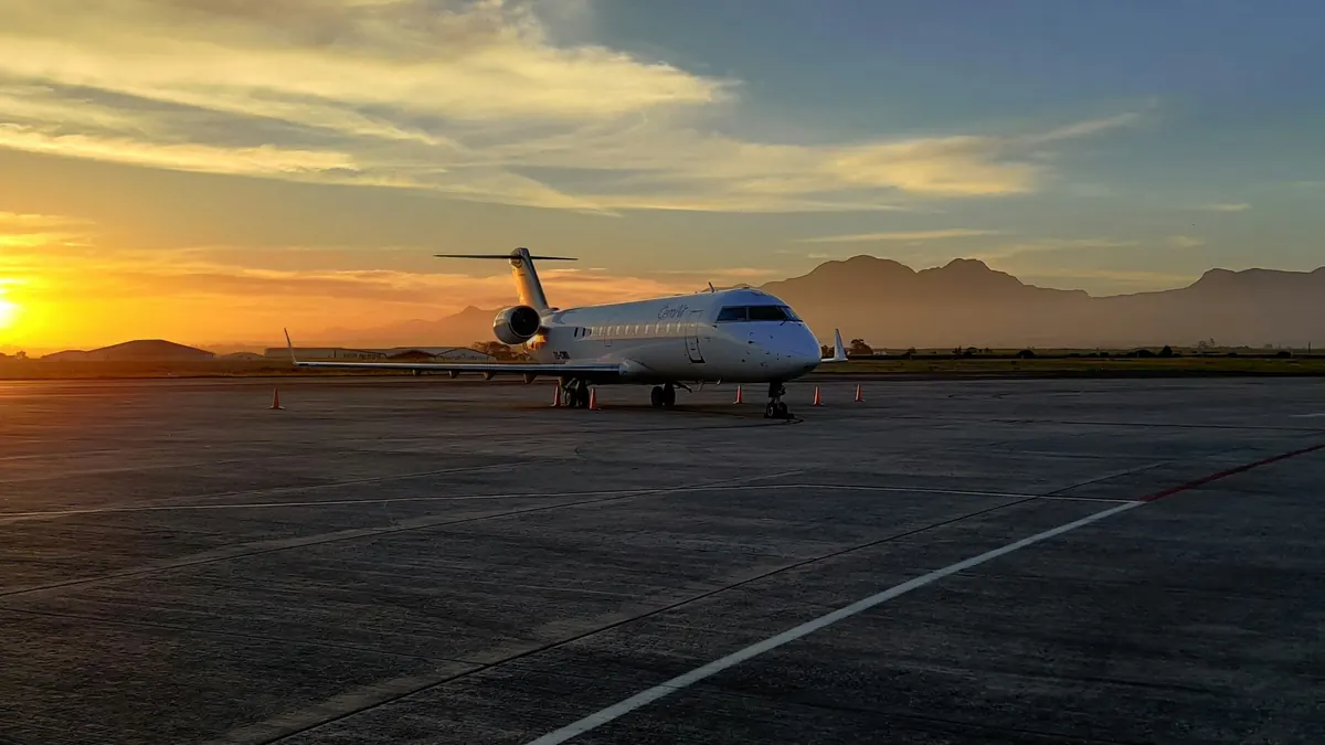 A business jet waiting on an empty ramp at sunset